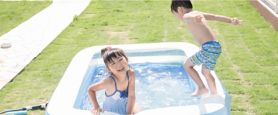 簡易プールで遊ぶ男の子と女の子